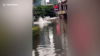 Vehicle almost tips over as driver battles through flooded street in Malaysia