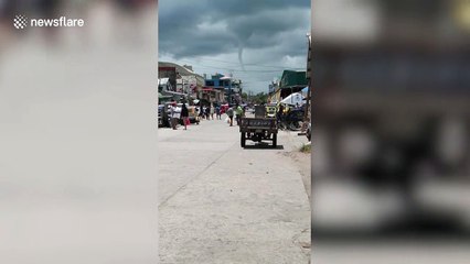 Landspout tornado stretches down from storm clouds in the Philippines