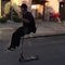 Guy Sits on Bar of Scooter While Riding Downhill