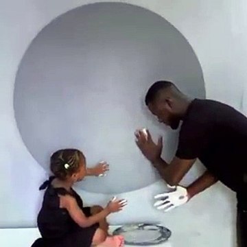 Cet artiste peint avec ses mains en jouant avec une fillette, le résultat est bluffant