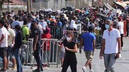 Thousands of migrants in Lesbos queue to enter new camp after devastating fire