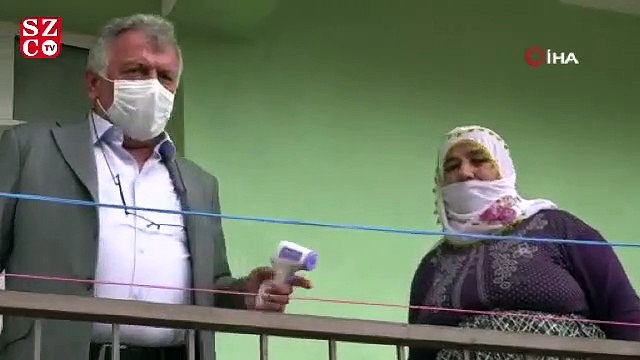 Elinde maskesi ve ateş ölçeriyle kapı kapı dolaşıyor