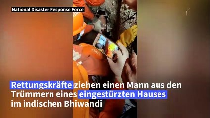 Helfer ziehen Mann aus eingestürztem Haus