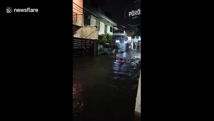 Children play in floodwaters as heavy rainfall hits Jakarta, Indonesia