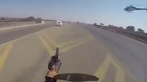 Un policier à moto tire sur une voiture volée lors d'une course poursuite