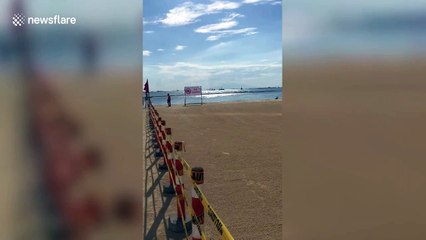 Woman poses in bikini on artificial white sand beach in the Philippines