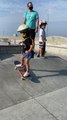 Little Girl Slides on Skateboard Between Two Cemented Ramps