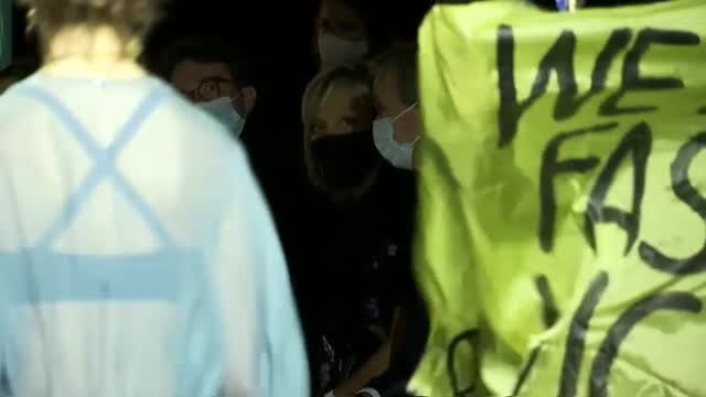 Una manifestante se sube a la pasarela en la Semana de la Moda de París