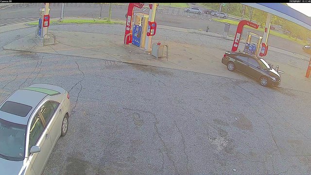Trash Truck Tire Meets Car Caboose in Gas Station Conundrum