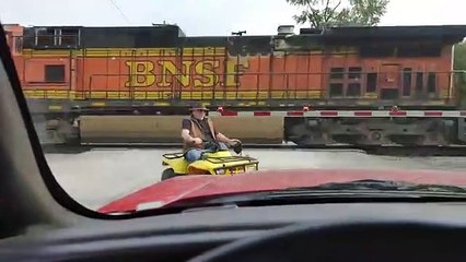 Cet homme en quad traverse la voie ferrée avec son chien et évite le pire de justesse