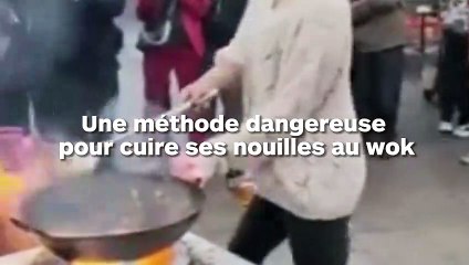 Elle balance son wok brûlant au-dessus de sa tête pour cuire ses nouilles