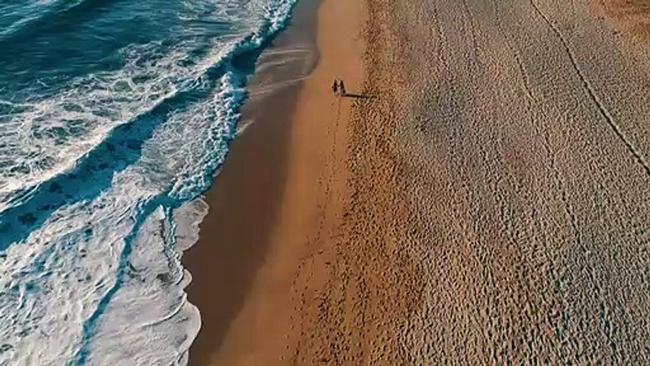 Couple walking down the beach natural beautiful royalty Free Stock no copyright video Free for commercial use dron dron aerial view