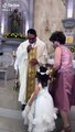 Niña choca la mano de un sacerdote durante su bendición