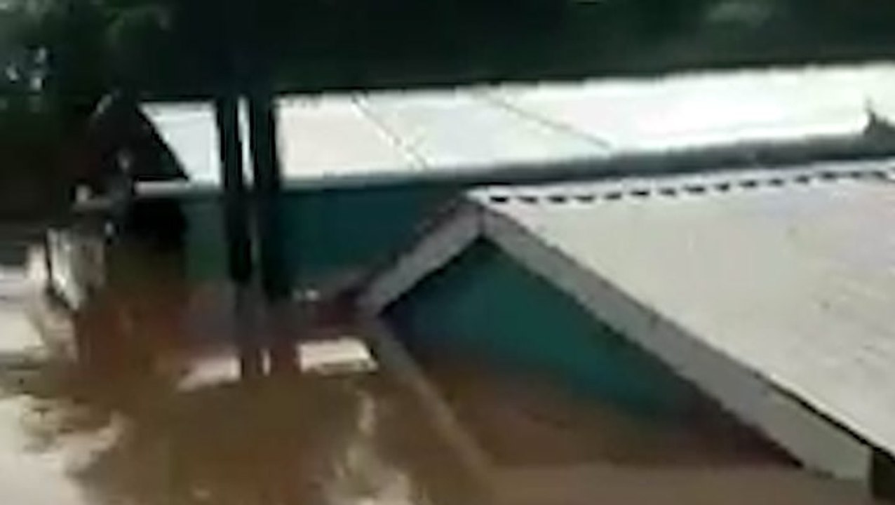 Buildings submerged by roof-high floodwaters