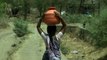 Women balancing pots of water from a well in Manegaon village