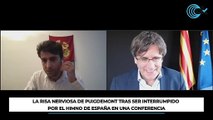 La risa nerviosa de Puigdemont tras ser interrumpido por el himno de España en una conferencia