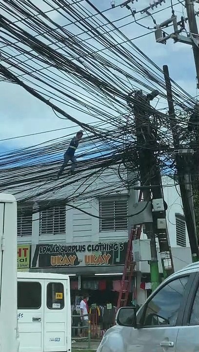 Worker Climbs Along Electric Wires