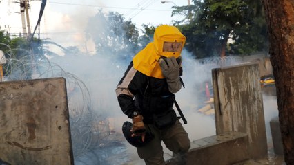 Riot police in Thailand fire tear gas and use water cannon at anti-government protesters