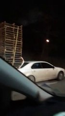 Large Stack of Pallets on Compact Car
