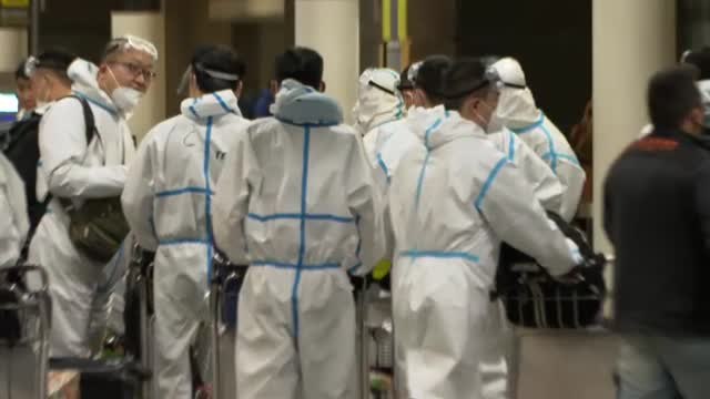 Marinos chinos aterrizan en Barcelona con trajes EPI completos, mascarillas y gafas