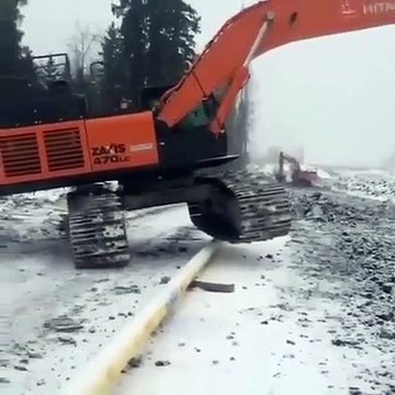 Ce conducteur de pelleteuse chevauche un tuyau avec son engin... doué