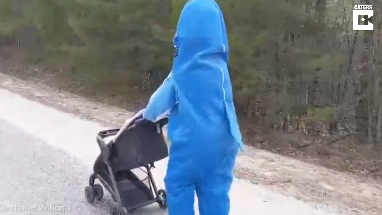 Mutter geht mit Baby im Hai-Kostüm spazieren