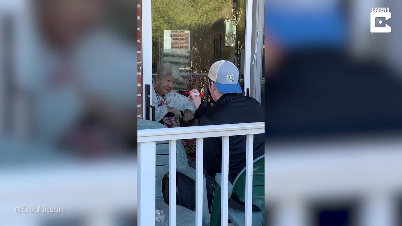 Enkel spielt mit seiner Großmutter Tic Tac Toe durchs Fenster