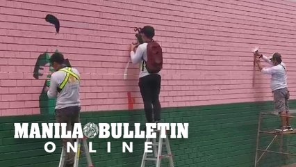 Freelance artists join together to paint a massive mural along Buendia