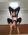 Woman Contorts On Top Of Other Woman Balancing In Handstand Position