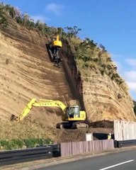 Cet ouvrier  dans son engin travaille à flan de falaise ! Vertigineux