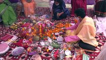 Woman blows conch, priest at Yagna_ Shankh Saptami or conch blowing prayer during Durga Puja