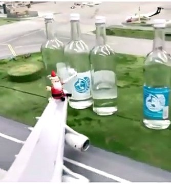 Ce petit Père Noël en miniature joue « Vive le vent » avec des bouteilles