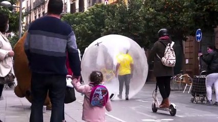 Un hombre en una burbuja se pasea por las calles de Sevilla