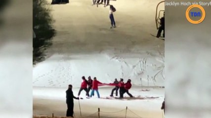 Une skieuse est pendue au télésiège accrochée à sa veste
