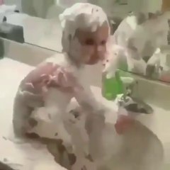 A small baby takes bath himself