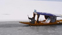 Fishermen break ice to steer their way through India's partially frozen Dal Lake