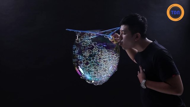 Il souffle 783 petites bulles de savon à l'intérieur d'une grande bulle