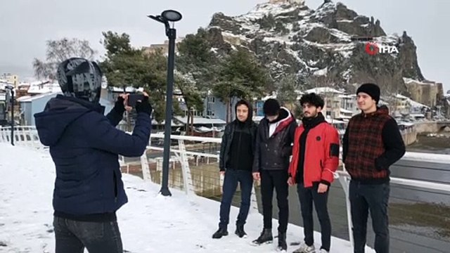 Beyaz örtüyle kaplanan tarihi kaleye karşı hatıra fotoğrafı