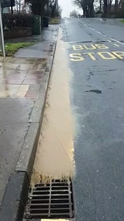 Brown water flows into drain