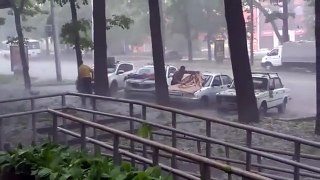 Russian woman protects the car from hail with her body