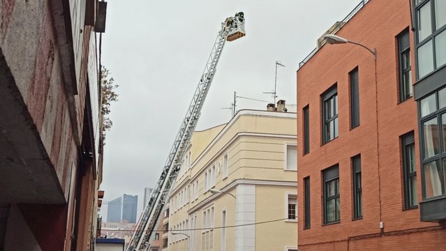 Bomberos trabajan en el incendio en una cubierta de un edificio de Tetuán