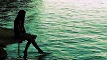 Girl Enjoying the Beach Water While Dangling Her Legs