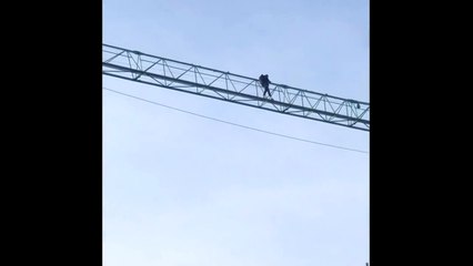 Un homme au sommet d'une grue près du pont des Trous