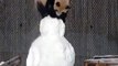 Un panda joue avec un bonhomme de neige