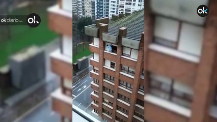 Una mujer de Gijón sube a la ventana de un séptimo piso para limpiar la persiana