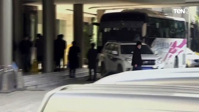 عشرات المحققين من خبراء من منظمة الصحة العالمية يستقلون حافلة كانت تنتظرهم عند مدخل الفندق في ووهان