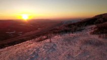 Soar above snow-capped Virginia mountains during a majestic sunrise