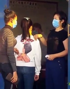 Une professeure utilise sa main pour vérifier la température de ses élèves