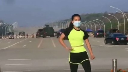 Image of the day: Myanmar woman dances as coup unfolds behind her