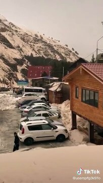 Une avalanche pousse des voitures sur un parking